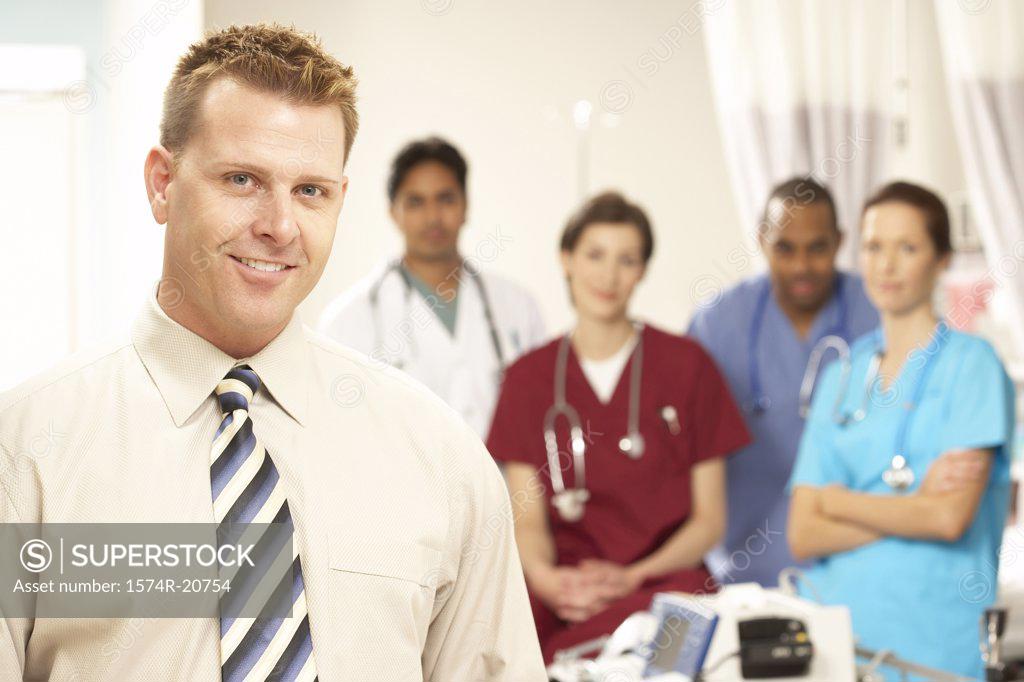 Stock Photo: 1574R-20754 Portrait of a male doctor smiling with his colleagues in the background