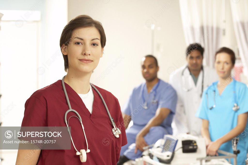 Stock Photo: 1574R-20757 Portrait of a female doctor standing with her colleagues in the background