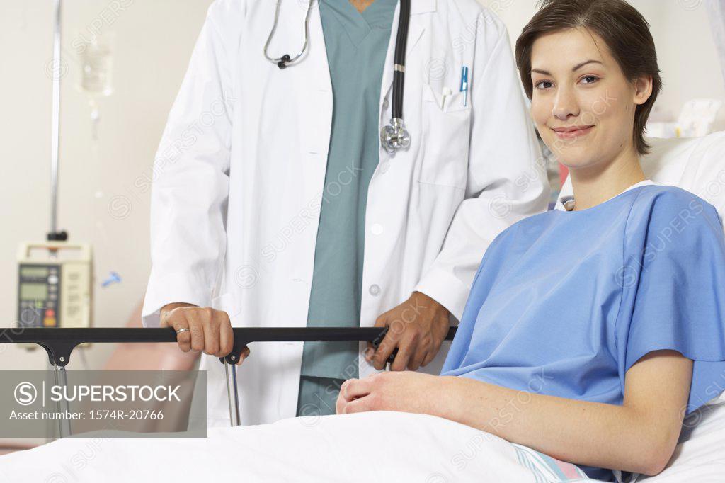 Stock Photo: 1574R-20766 Portrait of a female patient smiling with a male doctor standing beside her