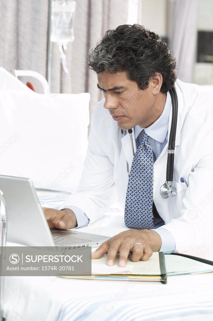 Stock Photo: 1574R-20781 Side profile of a male doctor using a laptop