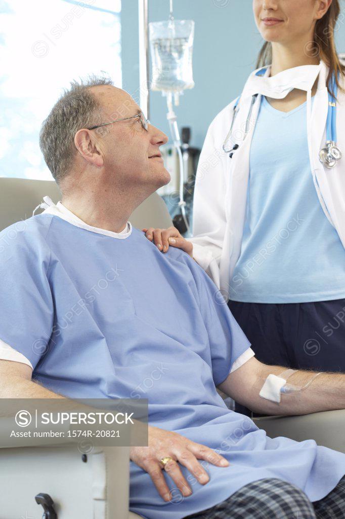 Stock Photo: 1574R-20821 Close-up of a male patient sitting in an armchair and a female doctor standing beside him