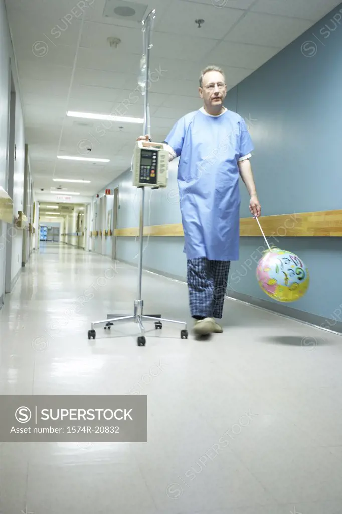 Low angle view of a male patient walking with an IV drip stand