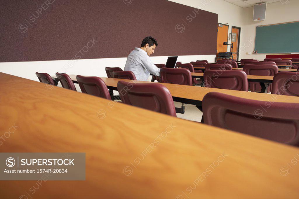 Stock Photo: 1574R-20834 Side profile of a college student sitting in a lecture hall and using a laptop