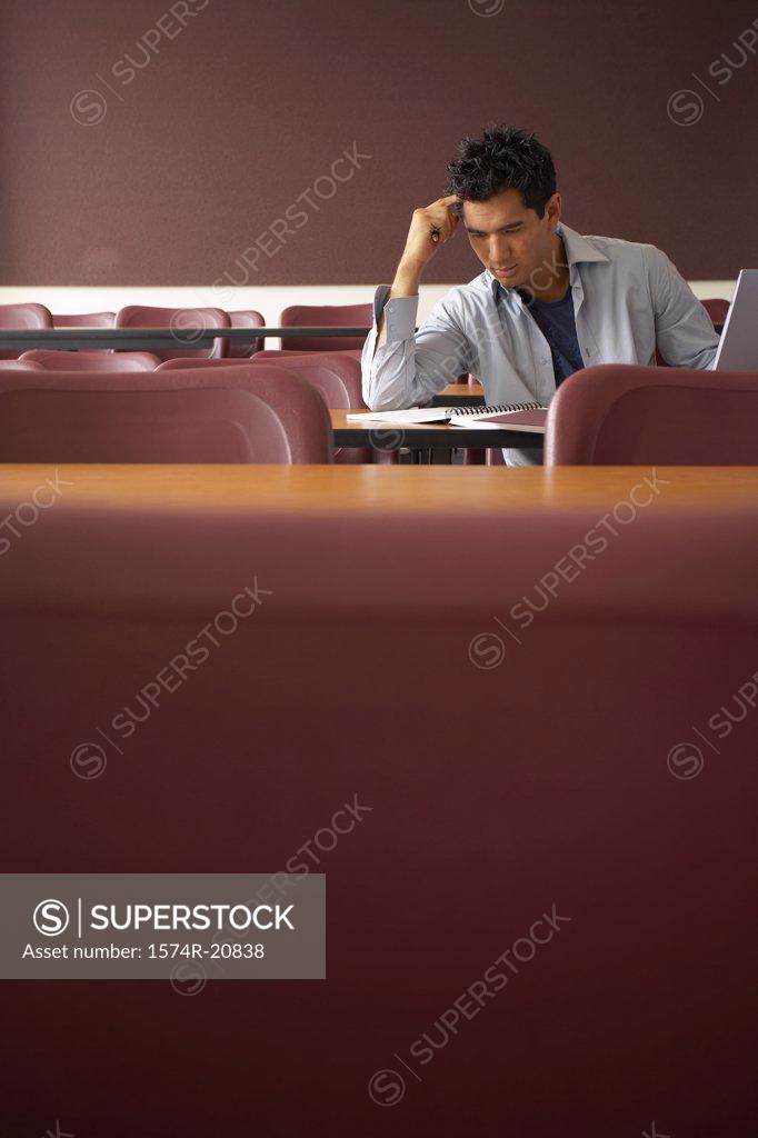 Stock Photo: 1574R-20838 College student sitting in a lecture hall and studying