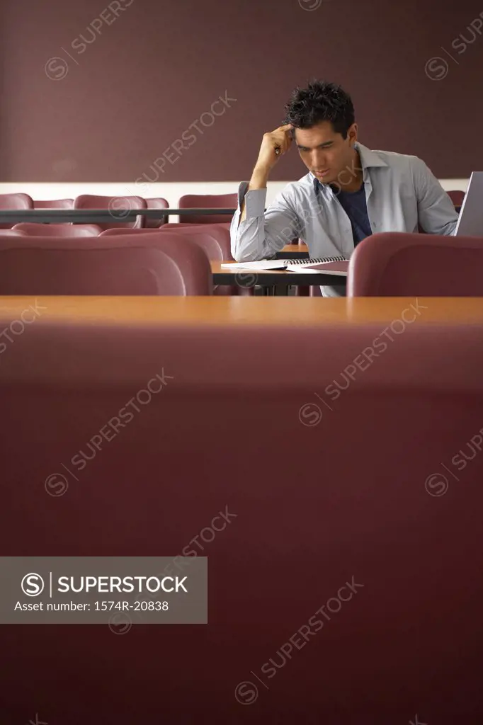 College student sitting in a lecture hall and studying