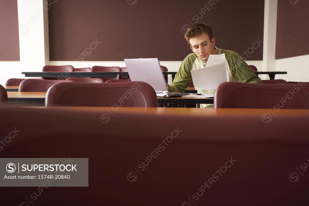 Stock Photo: 1574R-20840 College student sitting in a lecture hall and studying