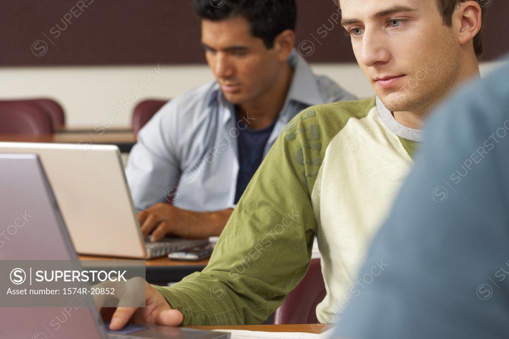 Stock Photo: 1574R-20852 Two college students sitting in a lecture hall and using laptops