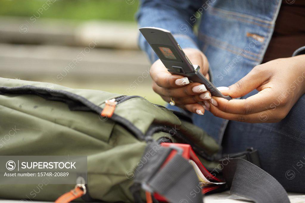 Stock Photo: 1574R-20889 Mid section view of a college student using a mobile phone