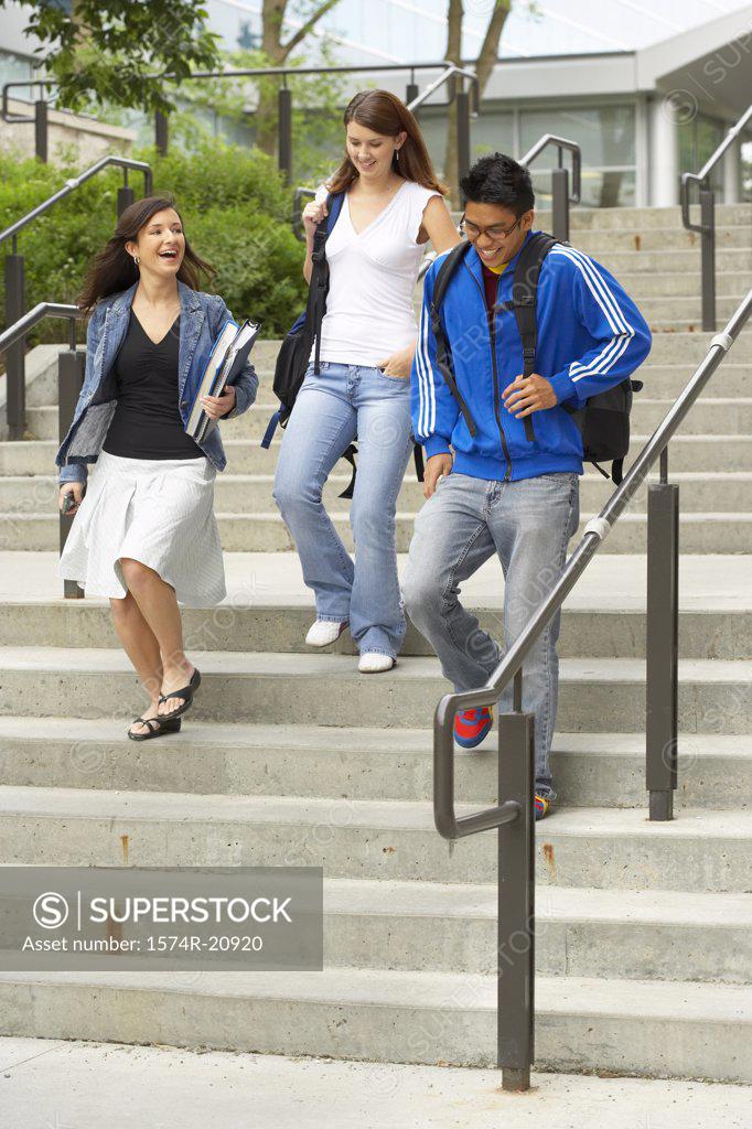 Stock Photo: 1574R-20920 Three college students moving down a staircase