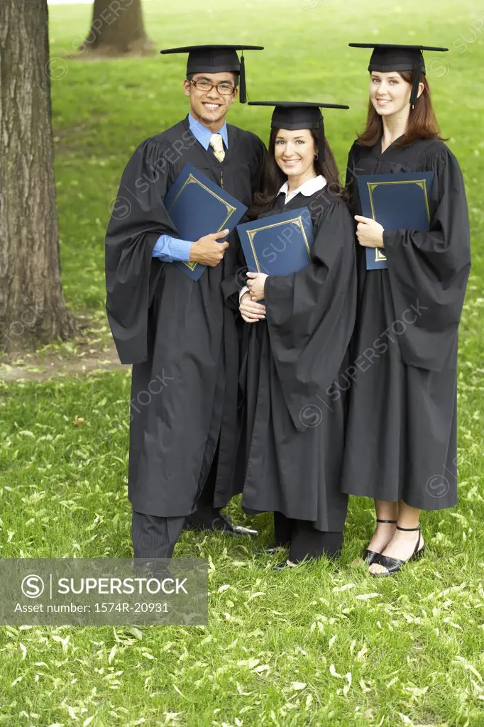 Two female graduates and a male graduate holding files