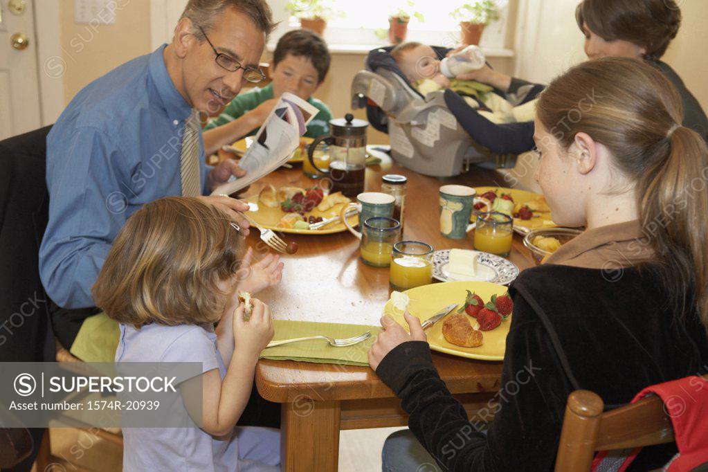 Stock Photo: 1574R-20939 Mid adult couple having breakfast with their two daughters and two sons