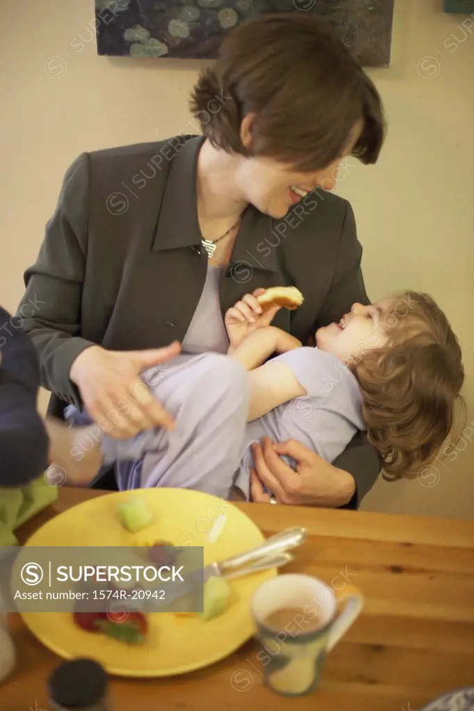Mid adult woman playing with her daughter at a dining table