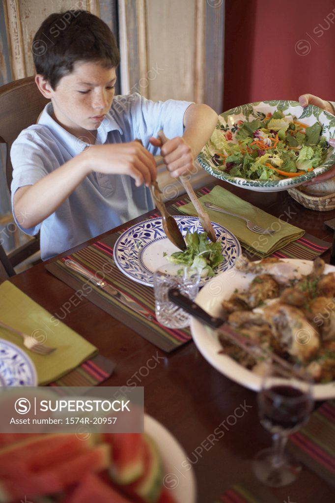 Stock Photo: 1574R-20957 High angle view of a boy sitting at a dining table