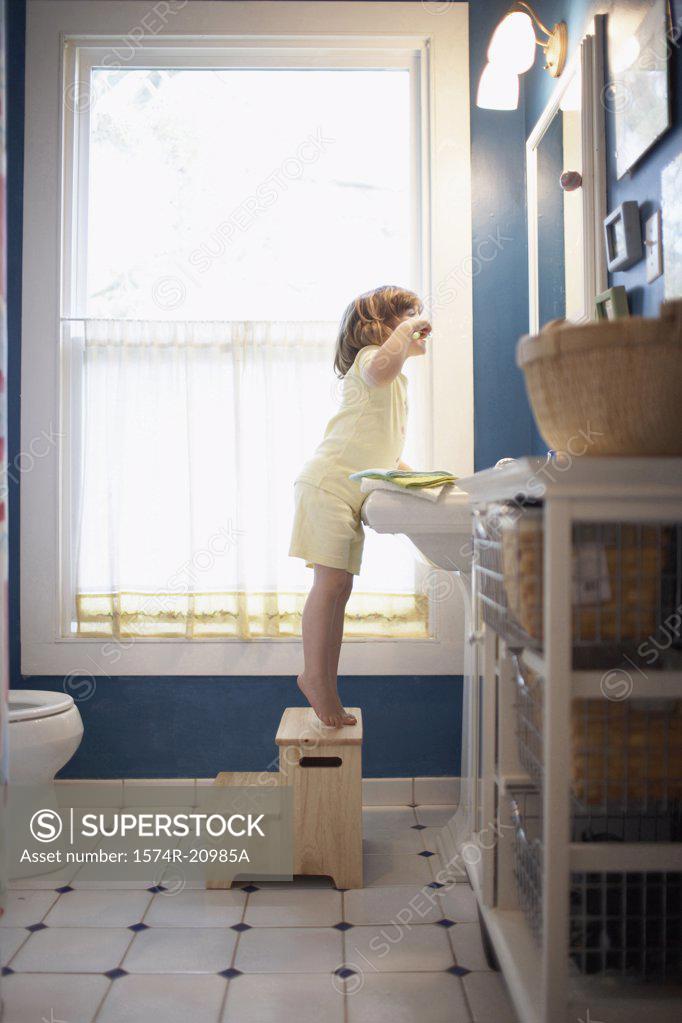 Stock Photo: 1574R-20985A Side profile of a girl brushing her teeth in the bathroom