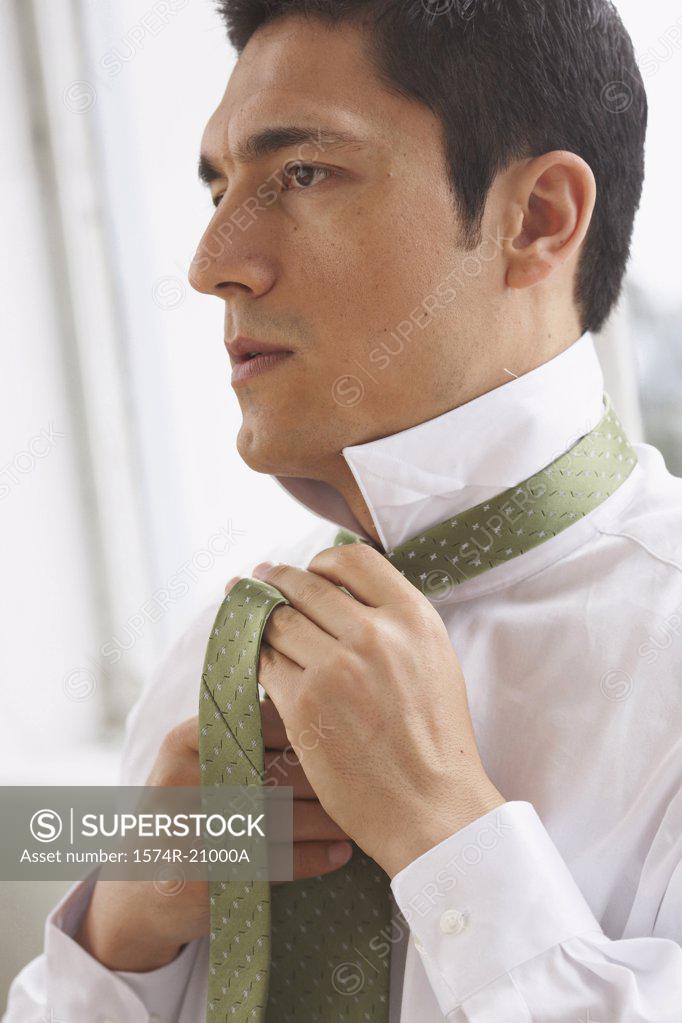 Stock Photo: 1574R-21000A Side profile of a businessman tying his tie