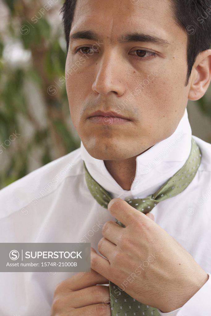 Stock Photo: 1574R-21000B Close-up of a businessman tying his tie
