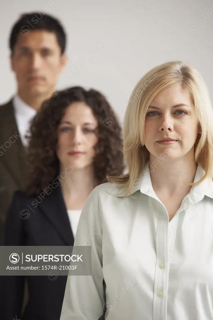 Portrait of two businesswomen and a businessman standing in a row