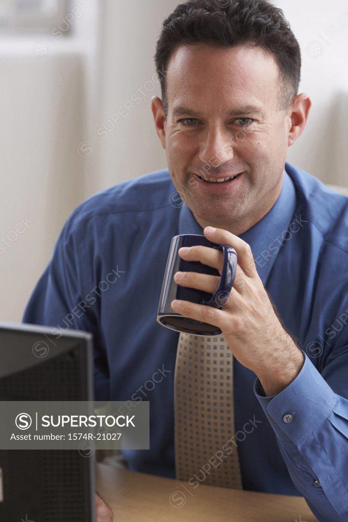 Stock Photo: 1574R-21027 Portrait of a businessman holding a coffee cup