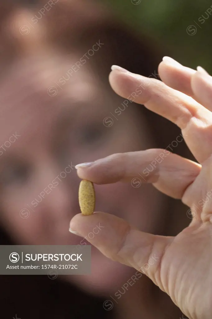 Close-up of a mature woman showing a pill