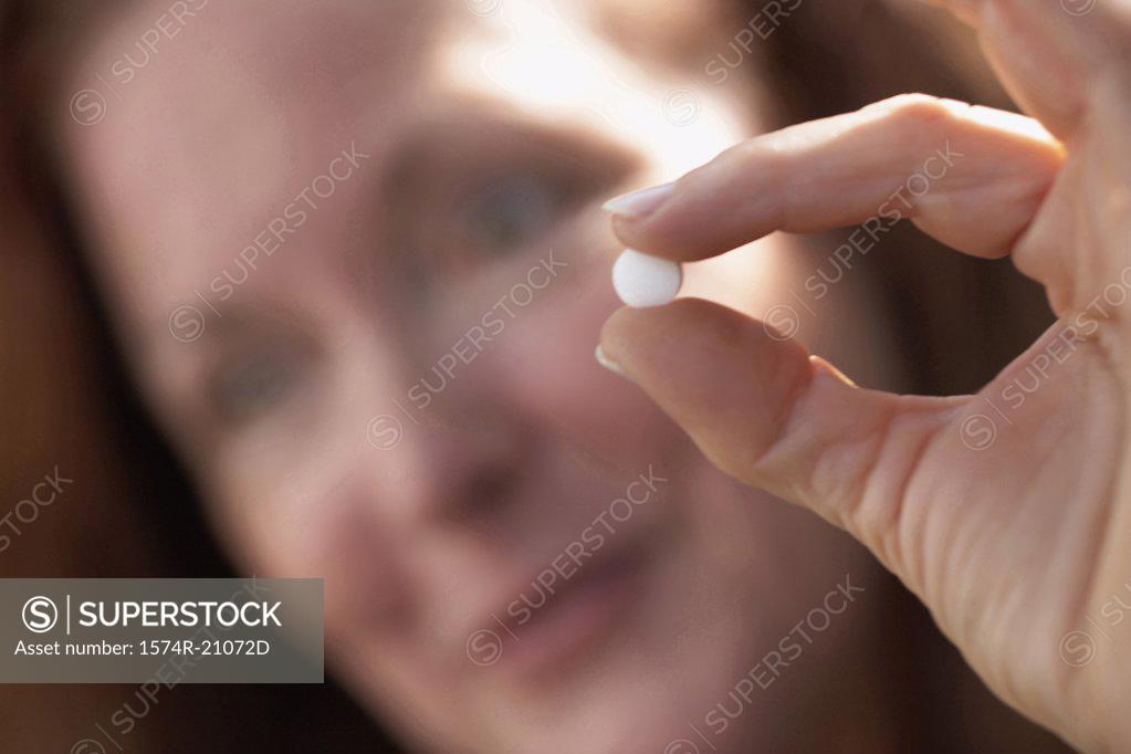 Stock Photo: 1574R-21072D Close-up of a mature woman showing a pill