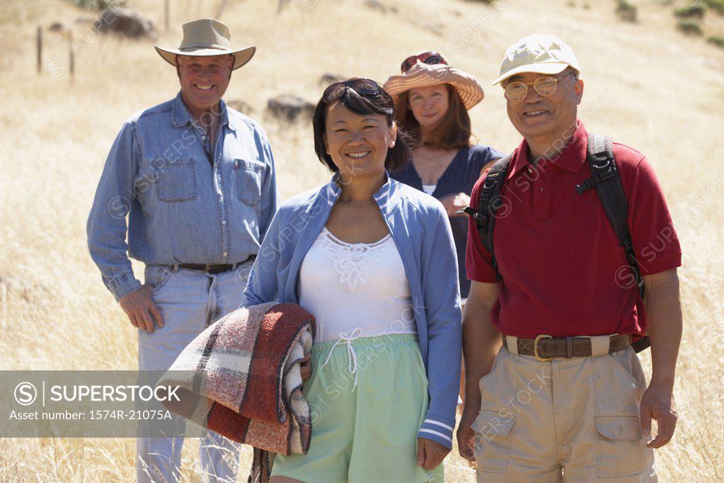 Stock Photo: 1574R-21075A Portrait of two mature couples standing in a field