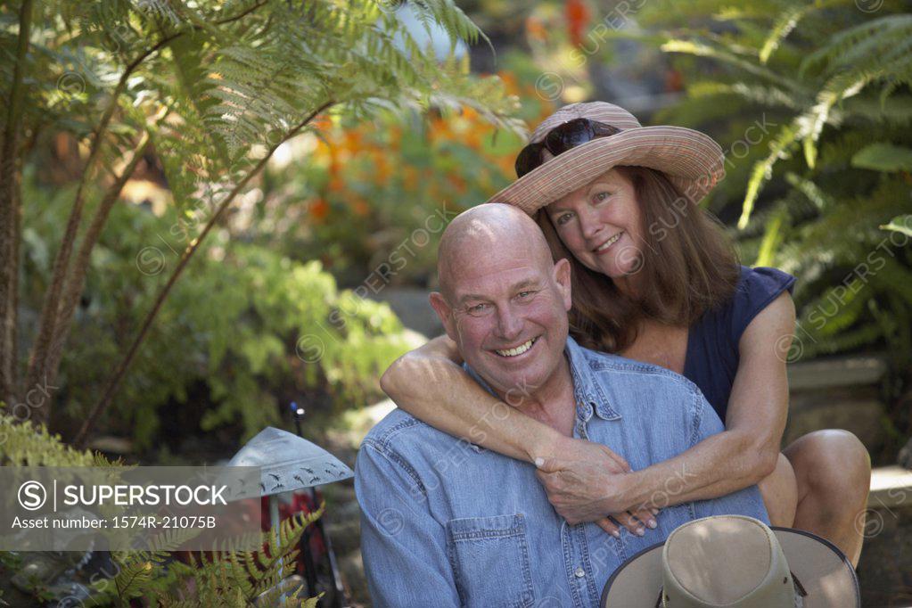 Stock Photo: 1574R-21075B Portrait of a mature woman embracing a mature man from behind
