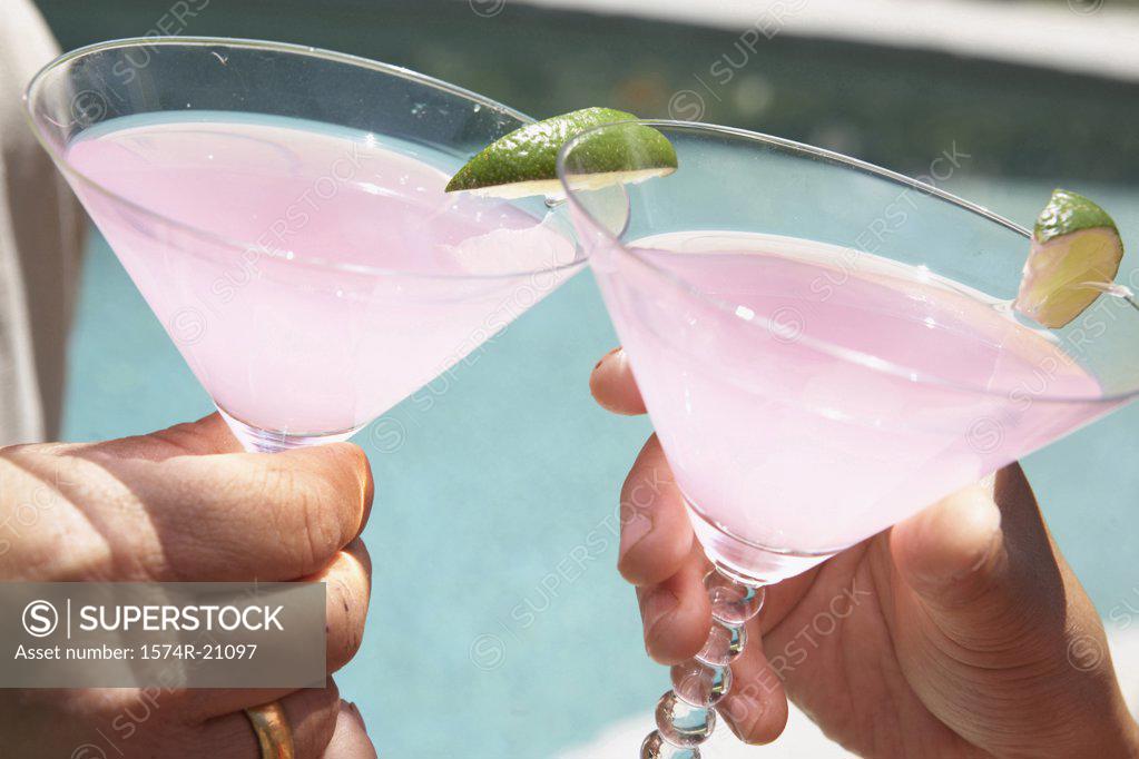 Stock Photo: 1574R-21097 Close-up of two people's hands toasting with martini glasses