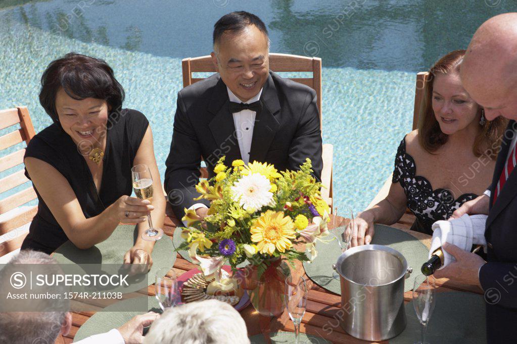 Stock Photo: 1574R-21103B High angle view of five mature people sitting in chairs at poolside