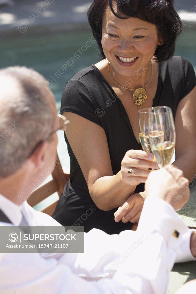 Stock Photo: 1574R-21107 Close-up of a mature woman and a mature man toasting with champagne flutes