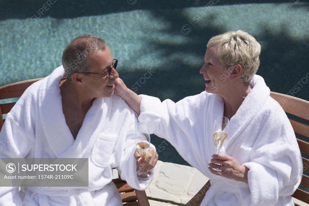 Stock Photo: 1574R-21109C Close-up of a mature couple holding champagne flutes at poolside