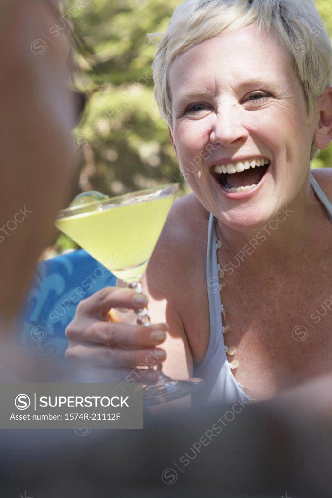Stock Photo: 1574R-21112F Close-up of a mature woman holding a martini and looking at a mature man