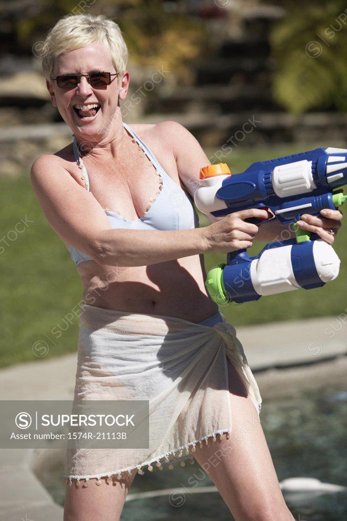Stock Photo: 1574R-21113B Mature woman spraying water with a squirt gun