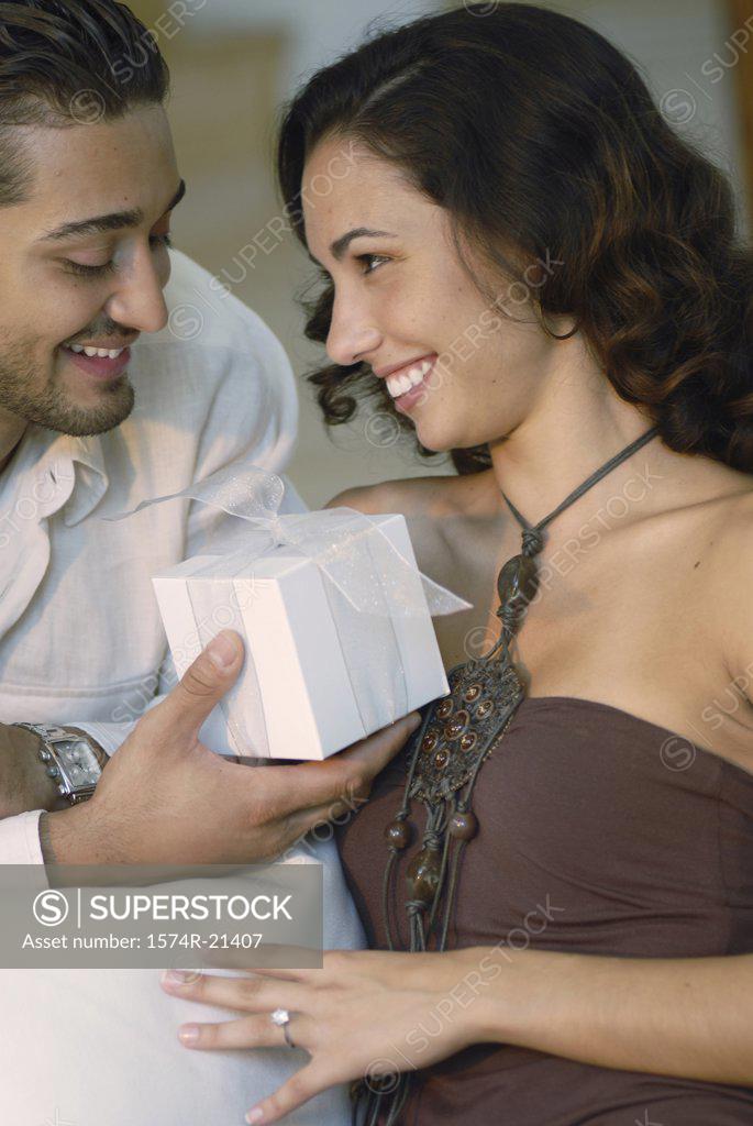 Stock Photo: 1574R-21407 Close-up of a young man giving a gift to a young woman