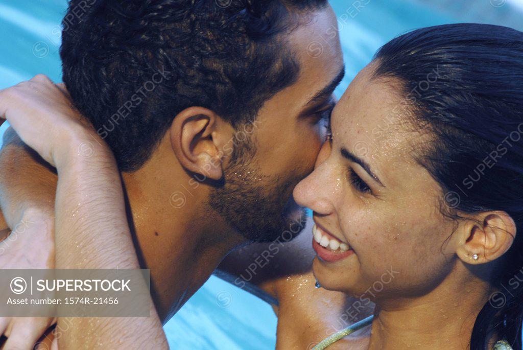 Stock Photo: 1574R-21456 Close-up of a young couple embracing each other in a swimming pool