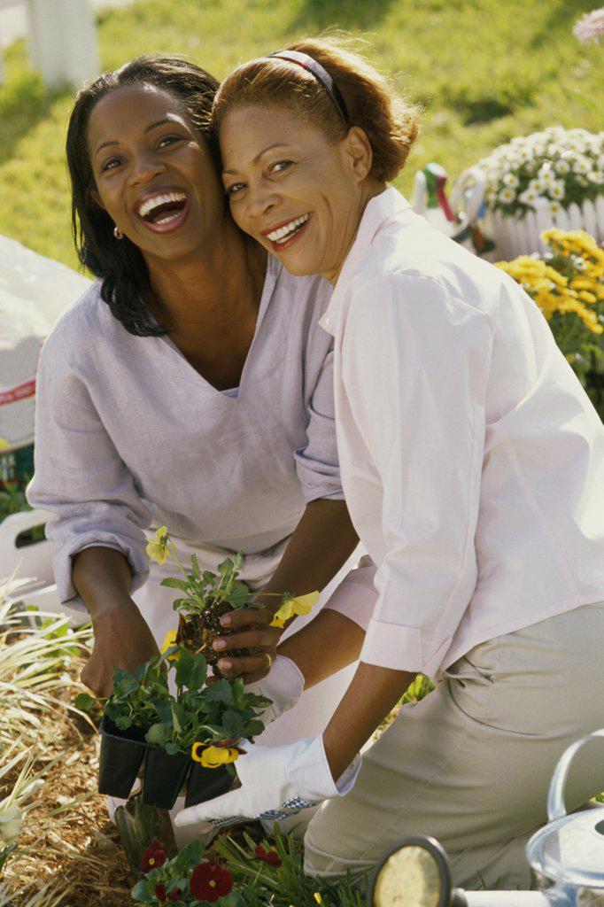 Portrait of a mother gardening with her daughter smiling