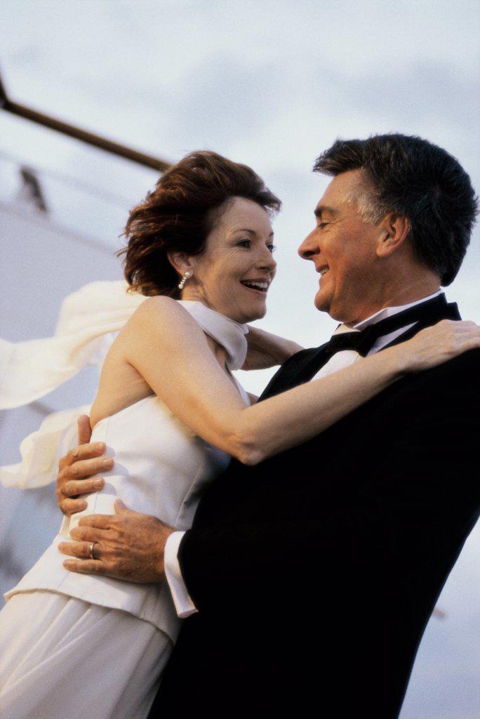 Side profile of a mature couple dancing on the deck of a cruise ship