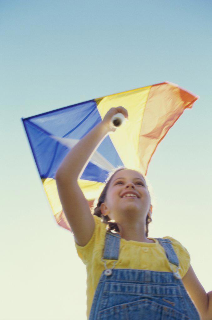 Low angle view of a girl flying a kite