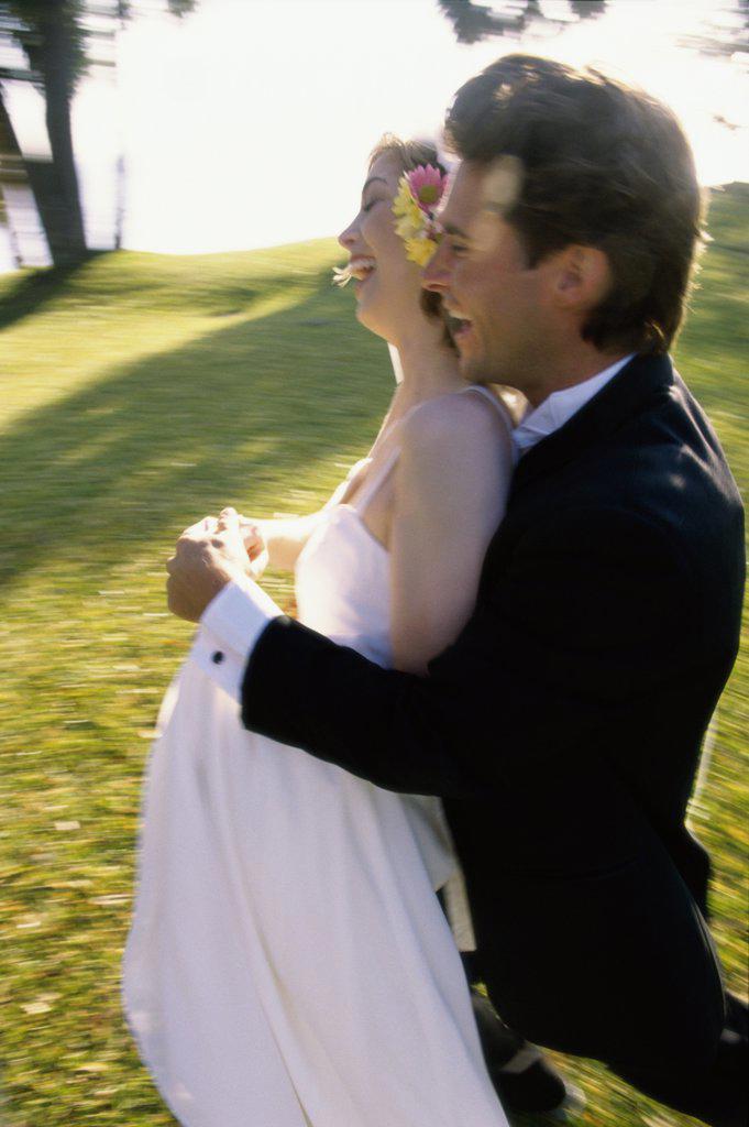 Side profile of a newlywed couple laughing