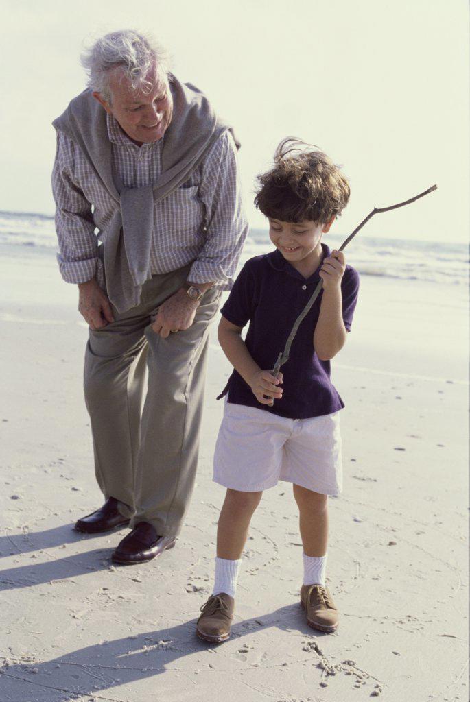 Grandfather playing with his grandson on the beach