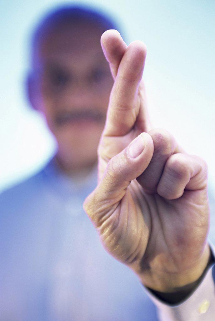 Close-up of a businessman's fingers crossed