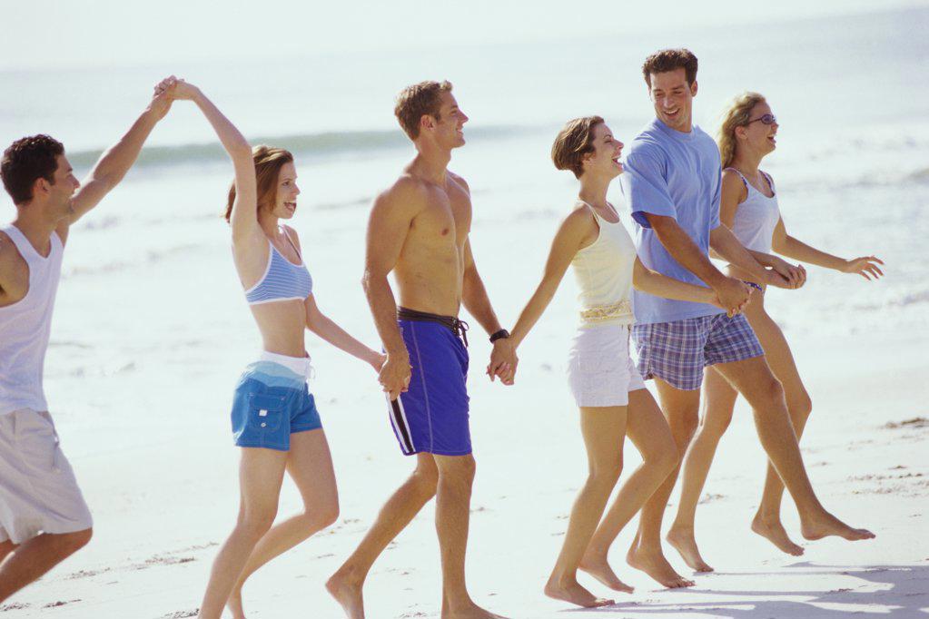 Group of young people walking on the beach
