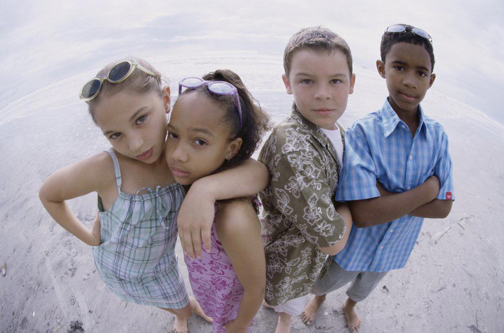 Portrait of two boys and two girls standing on the beach