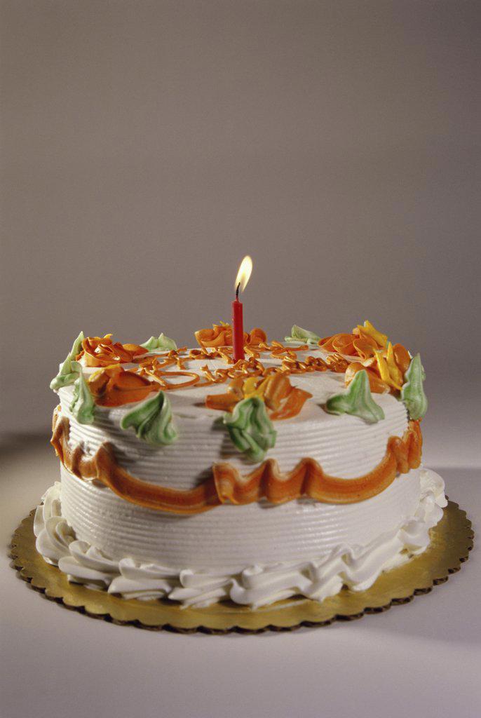 Decorated birthday cake with a lit candle