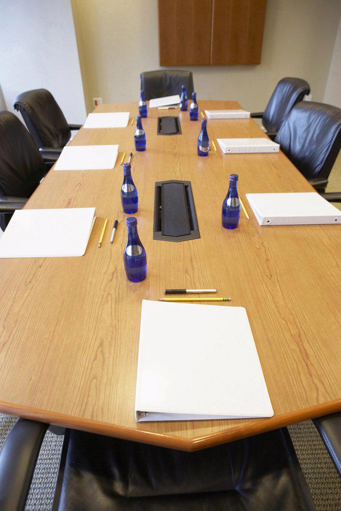 High angle view of water bottles and ring binder files on a conference table