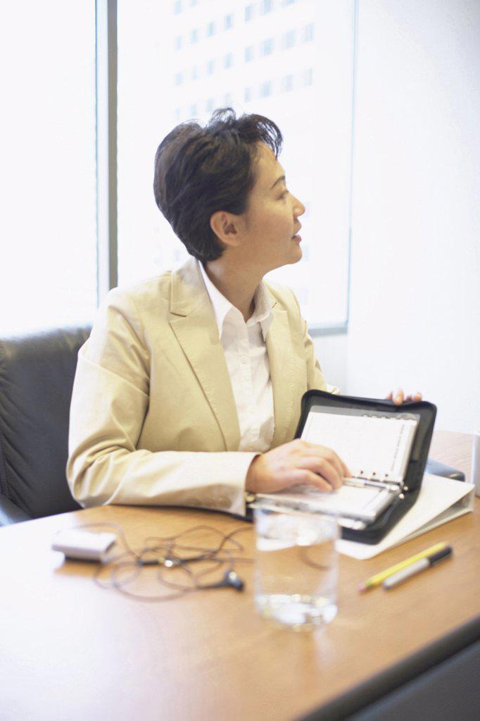 Businesswoman holding a personal organizer in an office