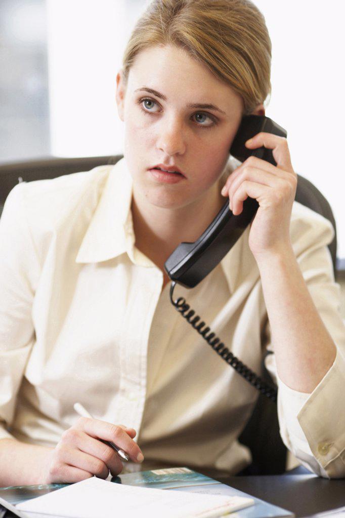 Close-up of a businesswoman using a telephone in an office