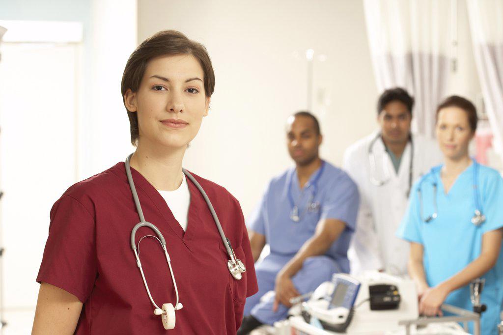 Portrait of a female doctor standing with her colleagues in the background