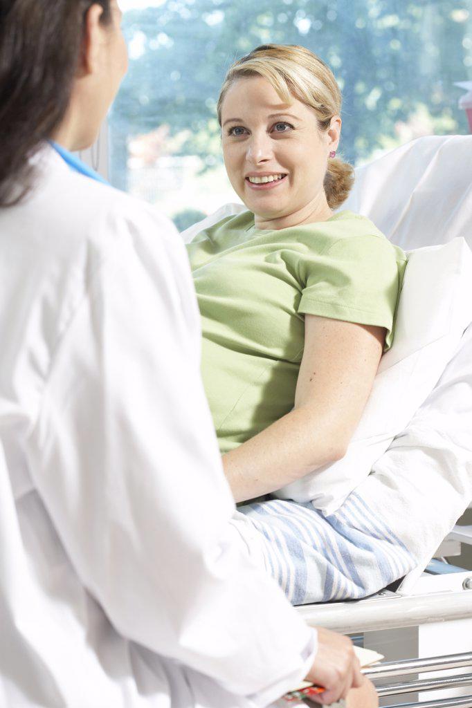 Side profile of a female doctor sitting in front of a pregnant woman