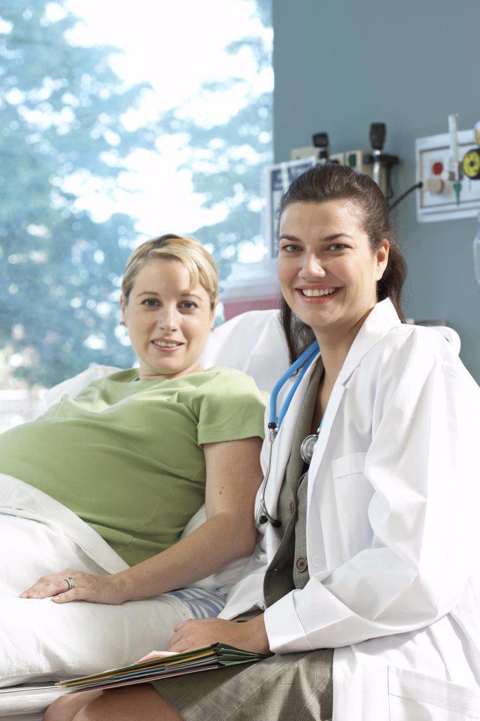 Portrait of a female doctor and a pregnant woman smiling