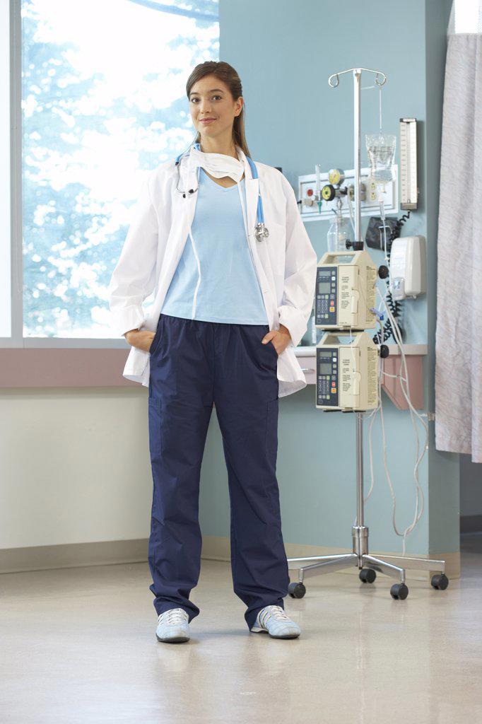 Portrait of a female doctor standing near an IV drip stand